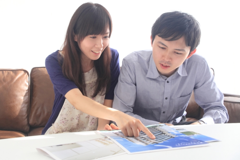住宅関係のチラシを見る若夫婦
