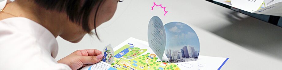 飛び出す印刷販促ツールに驚く女性